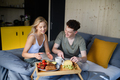 Young beautiful couple in love is sitting in bed and having healthy breakfast together. - PhotoDune Item for Sale