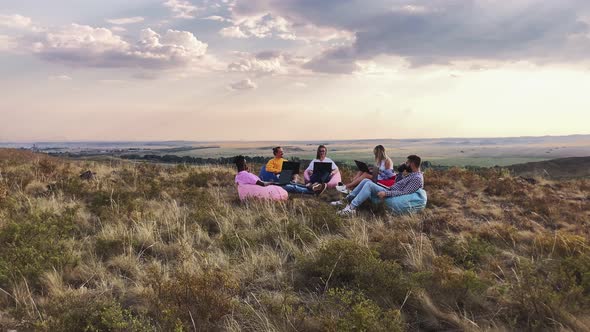 Group of International Students Sitting in Nature Chairs Bag with Laptops They Chatting and Drinking