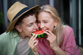 Cheerful young couple in love eating slice of watermelon together - PhotoDune Item for Sale