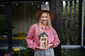 Young woman garedener holding bug and insect hotel on terrace in garden, sustainable lifestyle. - PhotoDune Item for Sale