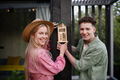 Young couple holding bug and insect hotel on terrace in garden, sustainable lifestyle. - PhotoDune Item for Sale