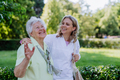 Portrait of caregiver with senior woman on walk in park with shopping bag, laughing and talking. - PhotoDune Item for Sale