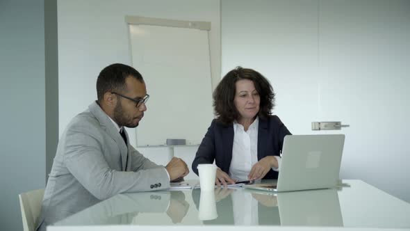 Smiling Manager Talking with Young Man in Office