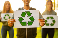 Man holding placard with recycling symbol with his enviromental team at park - PhotoDune Item for Sale