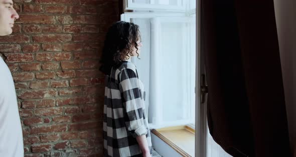 Young Couple Man and Woman Stay Near Window at Home