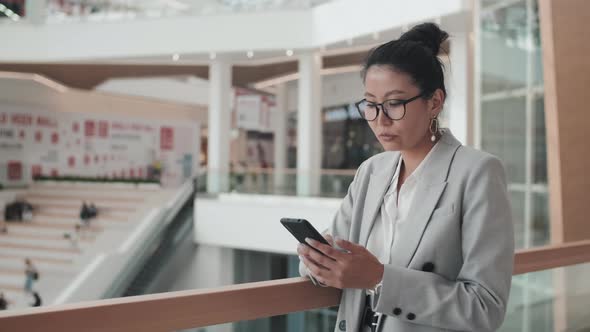 Businesswoman Using Mobile Phone in Office Building