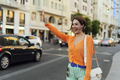 Smiling woman hailing a taxi in the city - PhotoDune Item for Sale