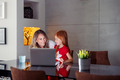 Mother assisting daughter with online lessons using laptop computer - PhotoDune Item for Sale