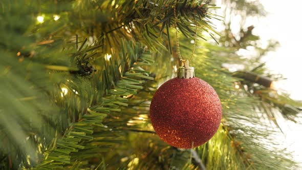 Close-up of red shiny bauble on the artificial tree 4K 2160p 30fps UltraHD footage - Christmas decor