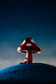 Low angle shoot of an astronaut lying down or taking a shelter under a red mushroom - PhotoDune Item for Sale