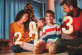 Parents and children holding illuminative numbers 2023 while celebrating New Year - PhotoDune Item for Sale