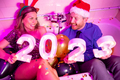 Couple holding numbers 2023 while having fun at New Year party - PhotoDune Item for Sale