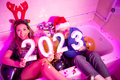 Couple holding numbers 2023 at New Year Eve party - PhotoDune Item for Sale