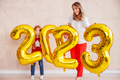 Mother and daughter holding balloons 2023 while celebrating New Year - PhotoDune Item for Sale