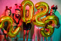Friends holding giant balloons shaped as numbers 2023 representing the upcoming New Year - PhotoDune Item for Sale