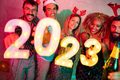 Friends holding illuminative numbers 2023 at New Year party - PhotoDune Item for Sale