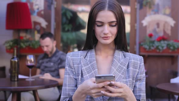 Beautiful Woman Using Mobile Phone At Outdoor Cafe