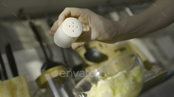  is added to bowl with filling for dish. Salting dishes in home kitchen. Salt in moderate amounts gives dish rich taste.