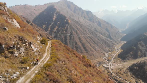 Man Ride Bicycle on the Mountain Road Shot By Drone