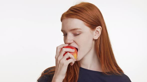 Cute Caucasian Teenage Foxy Girl in Dark Blue Tshirt Eating Apple Smiling Showing Ok on White