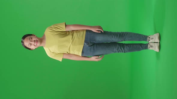 Full Body Of Young Asian Kid Girl Emotionally Flipping Something While Standing In The Green Screen