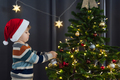 Child putting a ball on the Christmas tree at home - PhotoDune Item for Sale