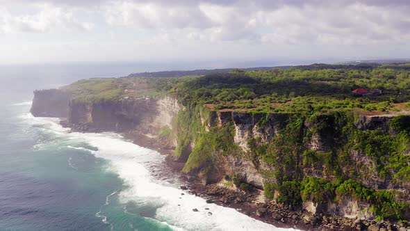 Uluwatu cliffs, Pull back aerial view revealing the sharp edge Cliff with lush green landscape, tert