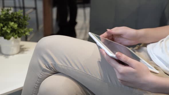 A Young Girl Uses a Tablet at Home