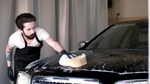 Man Washing His Car in a Garage