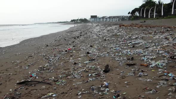 Pull back shot of a disgustingly polluted beach, plastic waste dumped in the ocean washed out by the