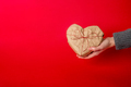 Hands holding Heart-shaped gift on red background - PhotoDune Item for Sale