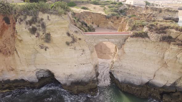 Aerial shot of Ponta da Piedade coastal cliff path and bridge in Portugal