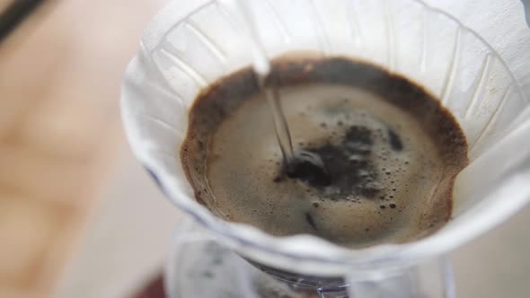 Close Up of a Person Pours Hot Water Into the Funnel Wets the Paper Filter