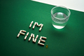 Capsules formed into the inscription I'm fine on a green background with a glass of water. - PhotoDune Item for Sale