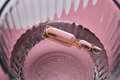 Ampoule in a mug with water on a pink background. The symbol of humidification. - PhotoDune Item for Sale