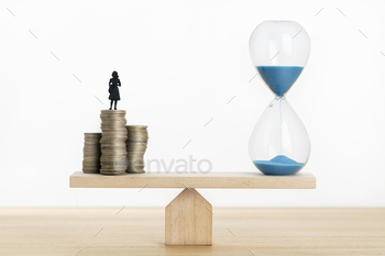 sswoman figurine on stacked coins on a Seesaw