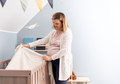 Pregnant woman preparing crib for expected newborn baby - PhotoDune Item for Sale