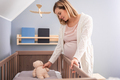 Pregnant woman preparing child room for expected newborn baby - PhotoDune Item for Sale