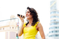 Smiling woman sending a voice message on the street - PhotoDune Item for Sale