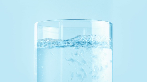 Jug Of Clear Water Poured Into Glass Closeup
