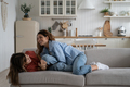 Happy family mother and teen daughter having fun, laughing while relaxing together on sofa at home - PhotoDune Item for Sale