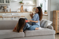 Friendly family of youth girl and mother tickle each other having fun sits on sofa in apartment - PhotoDune Item for Sale