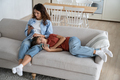 Family gadget addiction. Mother and teen daughter using smartphones while resting together on sofa - PhotoDune Item for Sale