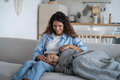 Loving caring mother touching hair of sleeping daughter girl and smiling, sitting on sofa at home - PhotoDune Item for Sale