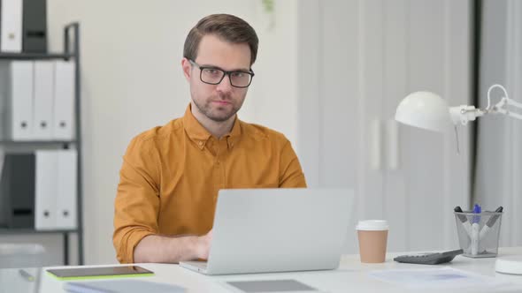 Young Man with Laptop Shaking Head No