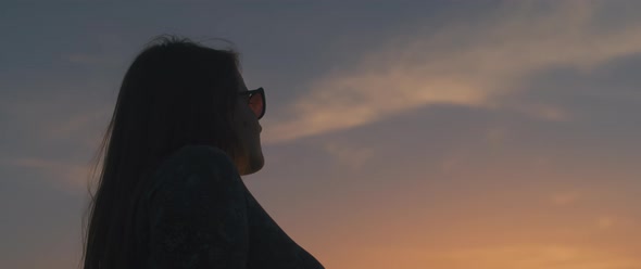 Woman watching beautiful golden sunset.