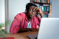 Bored unhappy young African man freelance worker looking at laptop screen cannot concentrate on work - PhotoDune Item for Sale