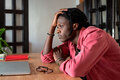 Upset young african guy remote worker coping with freelance burnout, sitting at desk with laptop - PhotoDune Item for Sale