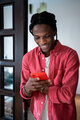 Young happy African American guy holding smartphone chatting with girlfriend at home - PhotoDune Item for Sale