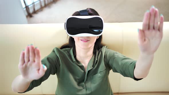 Woman Playing in Game Touching Something By Hands Wearing Modern Virtual Reality Glasses